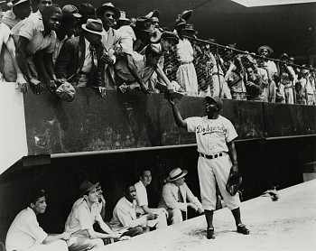 Work: Jackie Robinson returns an autograph to a fan in the stands. Dodgers' spring training in Cuidad Trujillo (now Santo Domingo), Dominican Republic